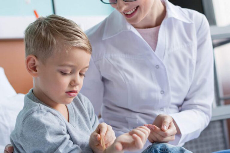 Consultație ORL pediatrică – medic examinează un băiat pentru afecțiuni precum vegetații adenoide (polipi) sau infecții respiratorii.