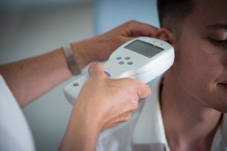 Evaluare ORL – medic utilizează un dispozitiv portabil pentru examinarea urechii unui pacient cu suspiciune de otită osoasă acută.