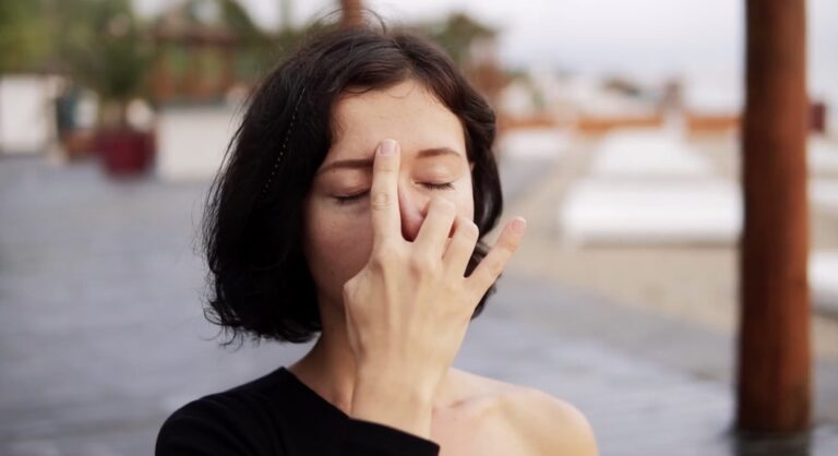 Femeie practicând exerciții de respirație nazală pentru reducerea sforăitului și îmbunătățirea calității somnului